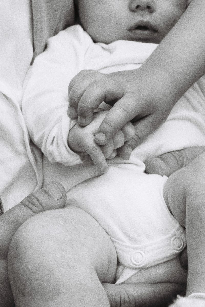 Zwart wit portret van baby, gezin die handen vasthouden, heel romantisch