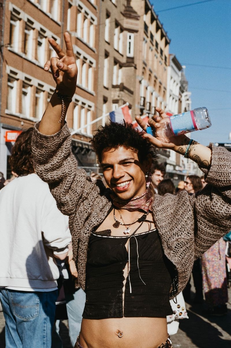 Jongen doet peace teken bij vrouwenmars in amsterdam, breedlachend en vrolijk