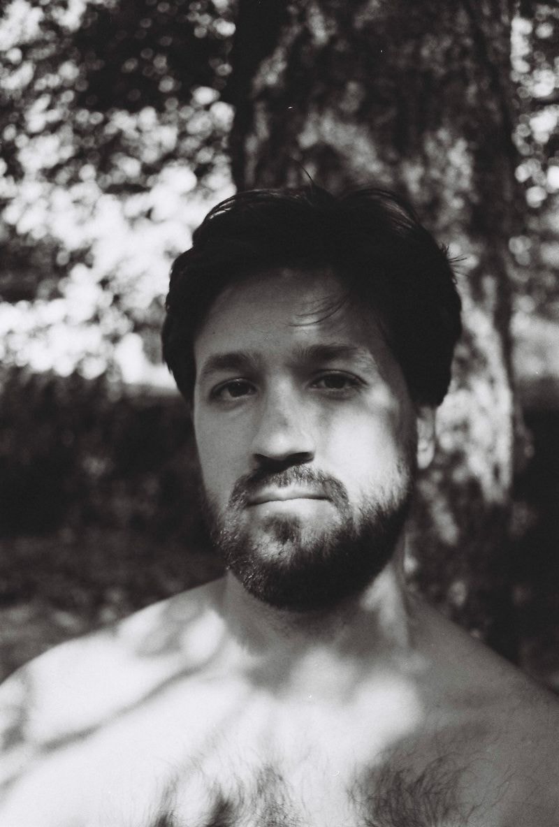 Man in zwart-wit met zachte, dromerige blik, gefotografeerd in België