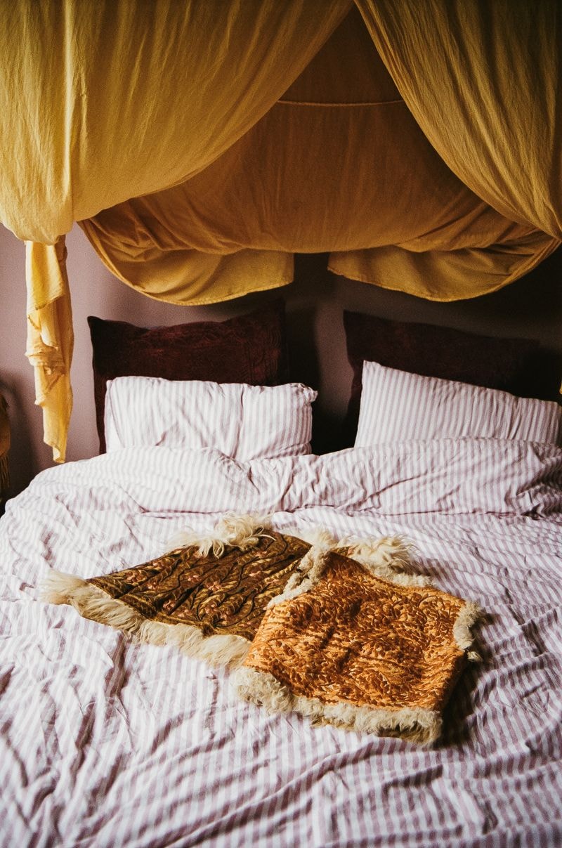 Twee klassieke waistcoats op bed, omgeven door een levendige en kleurrijke omgeving