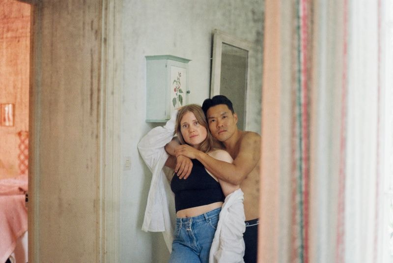 Koppel houdt elkaar vast, gezien door spiegel in Frans château