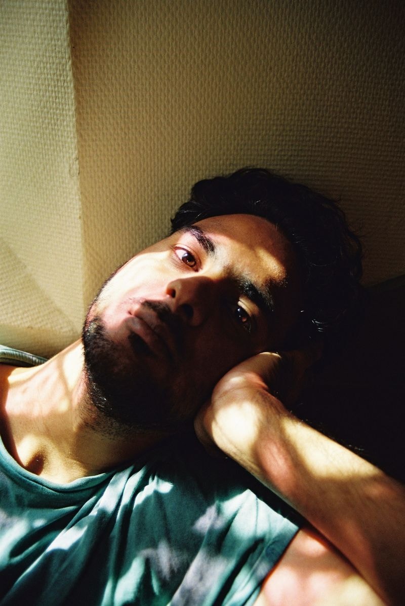 Jongen op kleurrijke trap in Frankrijk, met een dromerige blik en zacht licht