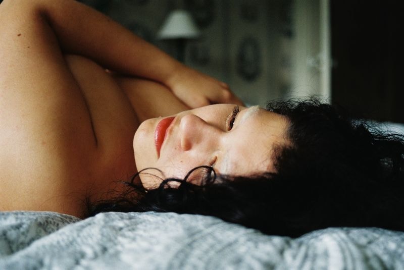 Meisje op bed van zijkant in Frans chateau