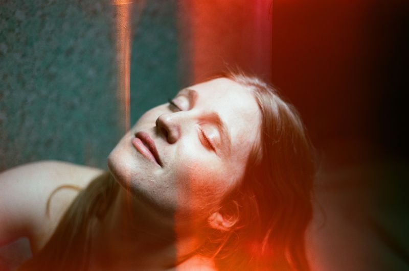 Meisje met gesloten ogen en lichtlek over haar gezicht