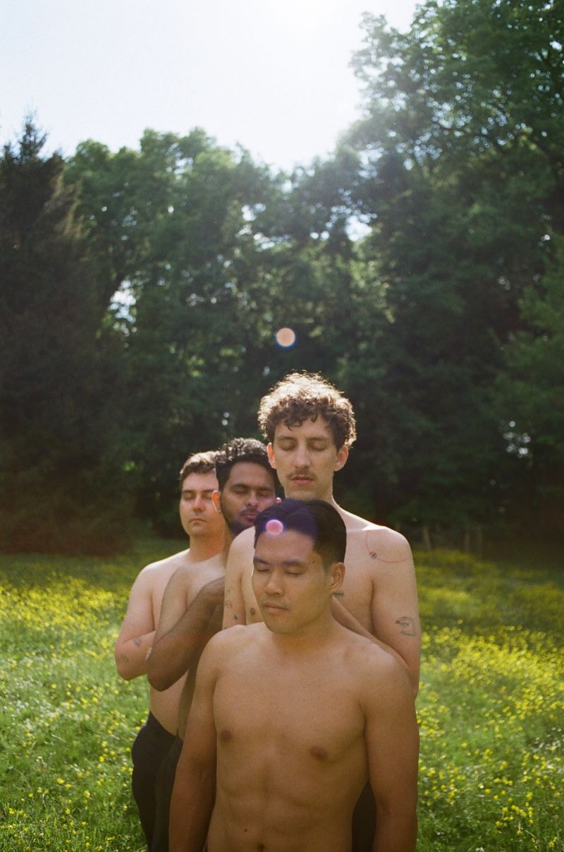 Vier mannen staand in groen veld tijdens het gouden uur in Frankrijk