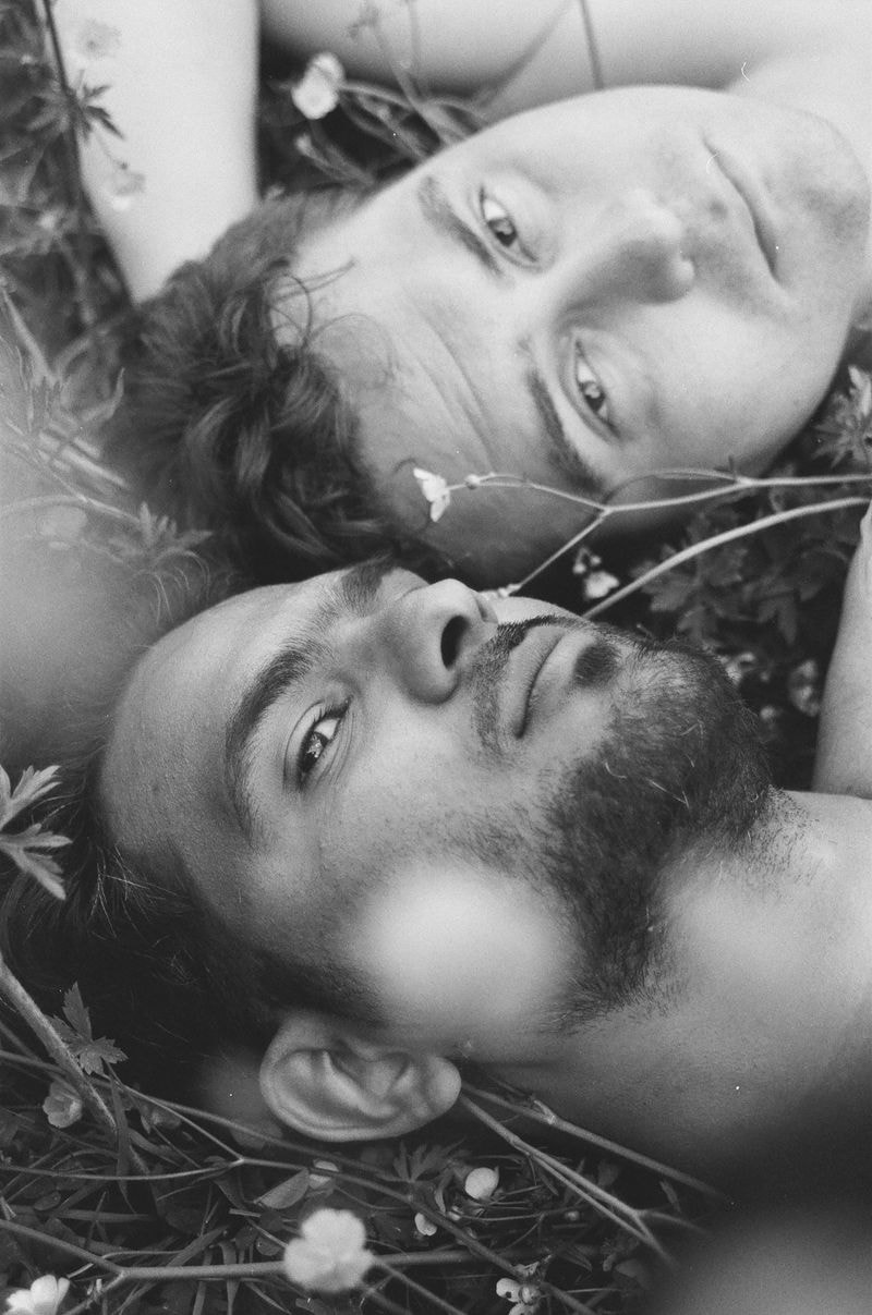 Zwart-wit portret van twee mannen naast elkaar in veld, één kijkt weg, de ander kijkt in de camera - in Frankrijk