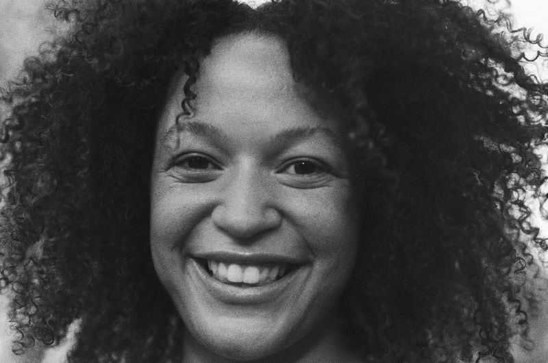 Zwart-wit portret van meisje met krullend haar en brede glimlach, lachend naar de camera in Utrecht