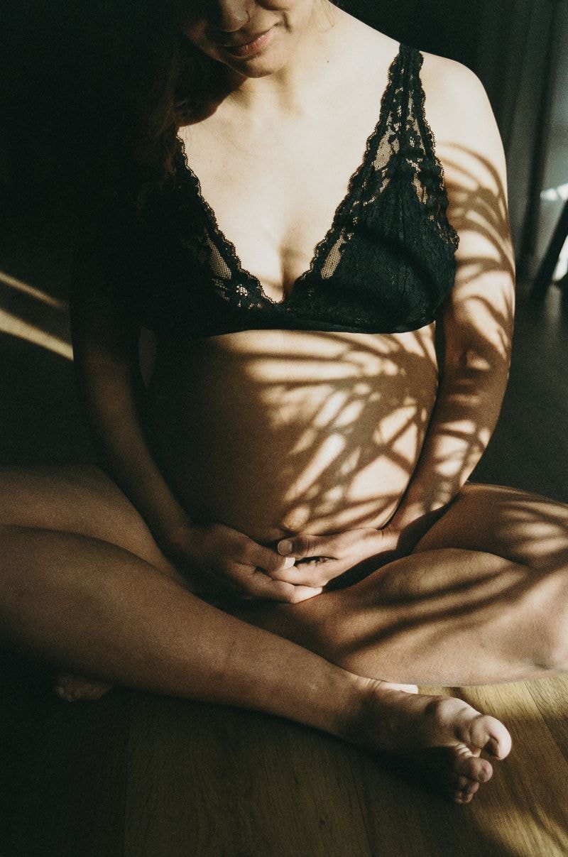 Zwangere buik met schaduw van plant op de huid